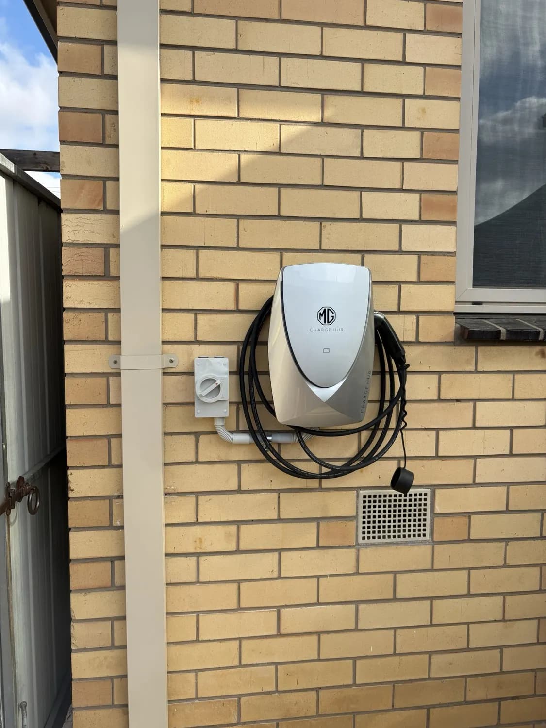 MG Charge Hub EV charger installed on an outdoor brick wall in Melbourne